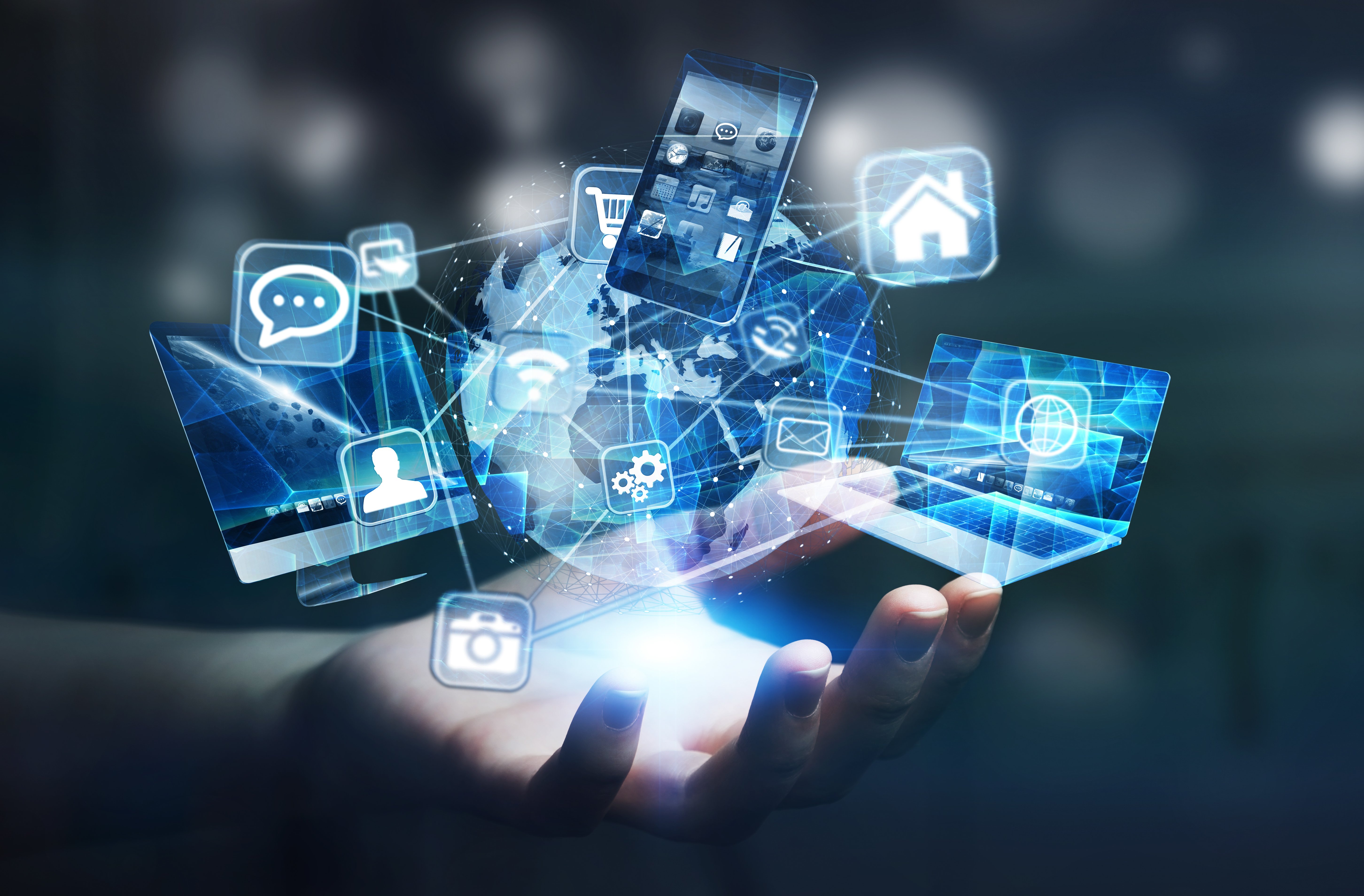 Tech devices and icons connected to a digital planet earth in a businesswoman's hand