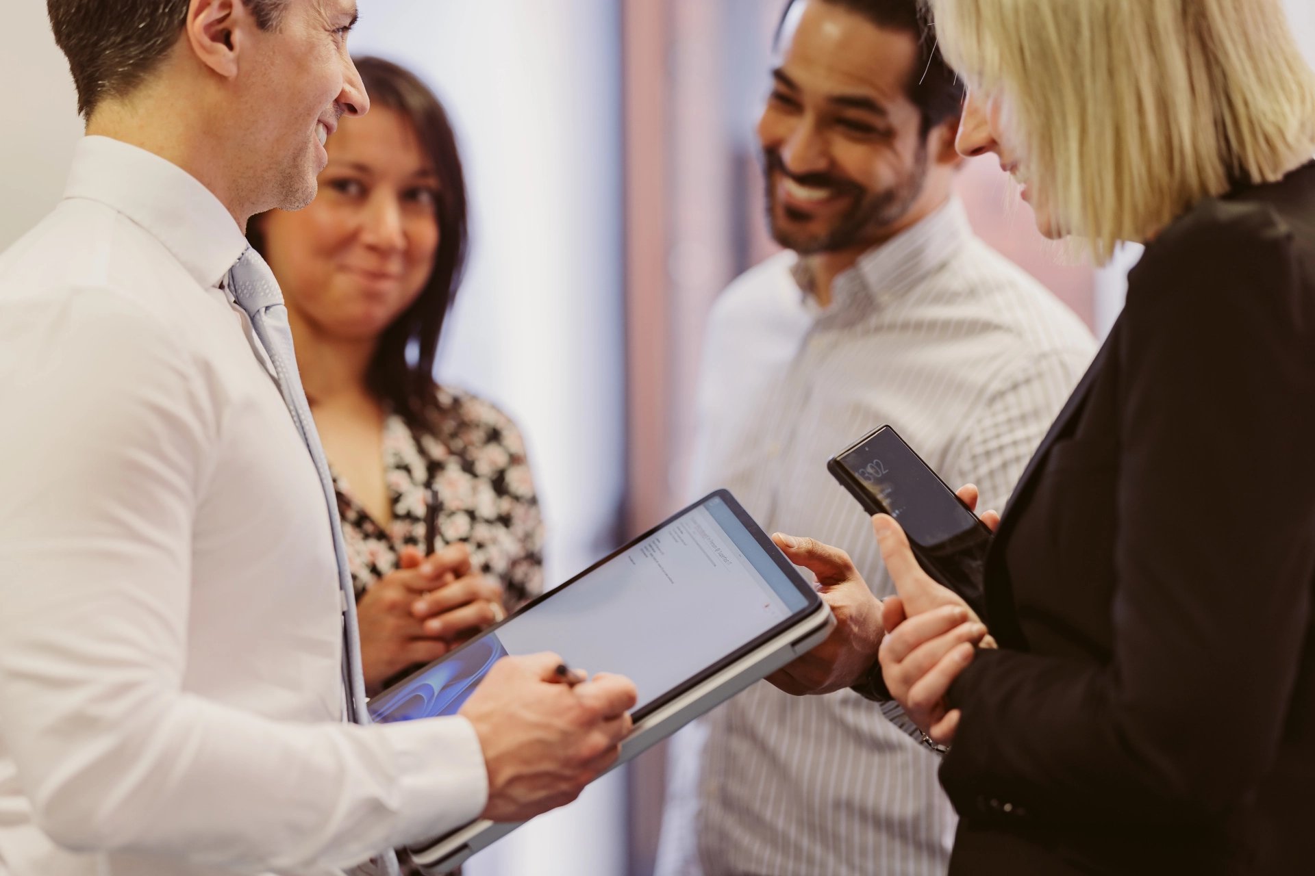 Colleagues working together around a tablet in the office